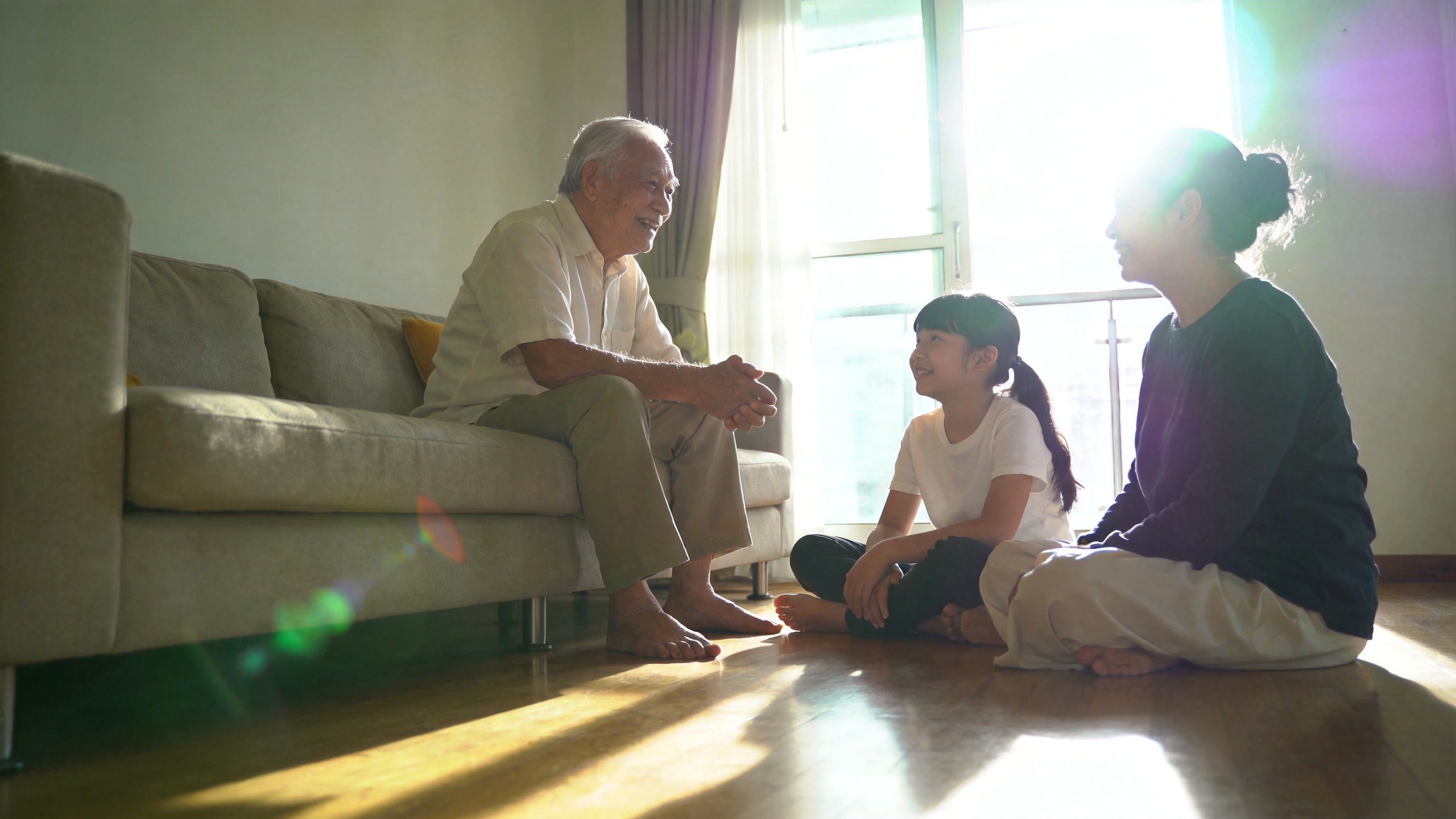 温馨的居家场景，子女陪伴老人，象征医疗险与意外险组合带来的家庭健康保障与安心生活