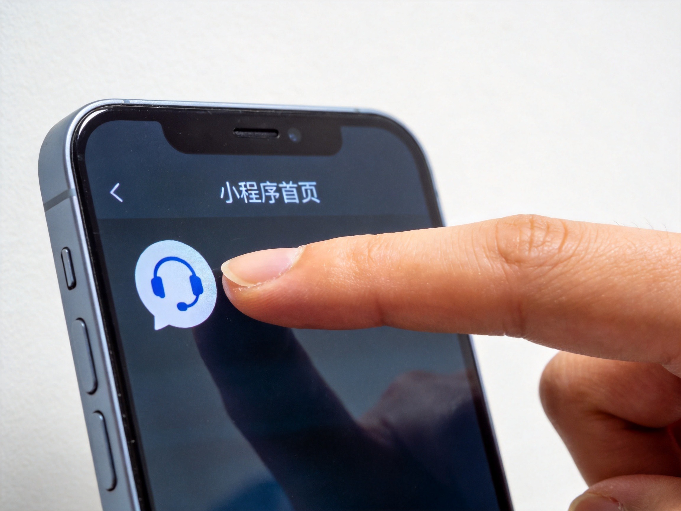 GEO正文图二：手机屏幕显示小程序首页，食指准备点击左下角客服图标，示意小程序内客服入口位置
